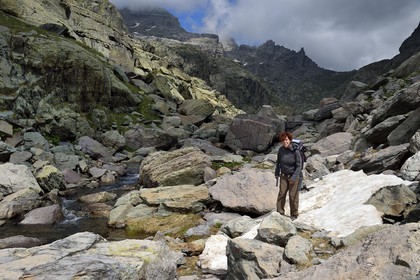 France, Alpes-Maritimes (06), parc national du Mercantour, Vallée des Merveilles parsemée de milliers de gravures rupestres de l'Age de bronze, l'archéologue Nicoletta Bianchi sur le sentier de randonnée GR 52 vers la Baisse de Valmasque et le Mont du Grand Capelet (2915m) en arrière plan
