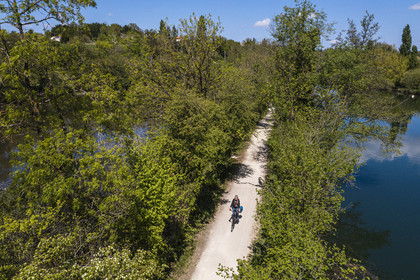 France, Charente (16), Fléac, une cycliste progresse entre deux bras de la Charente sur l'ancien chemin de halage devenu la véloroute La Flow Vélo (vue aérienne)