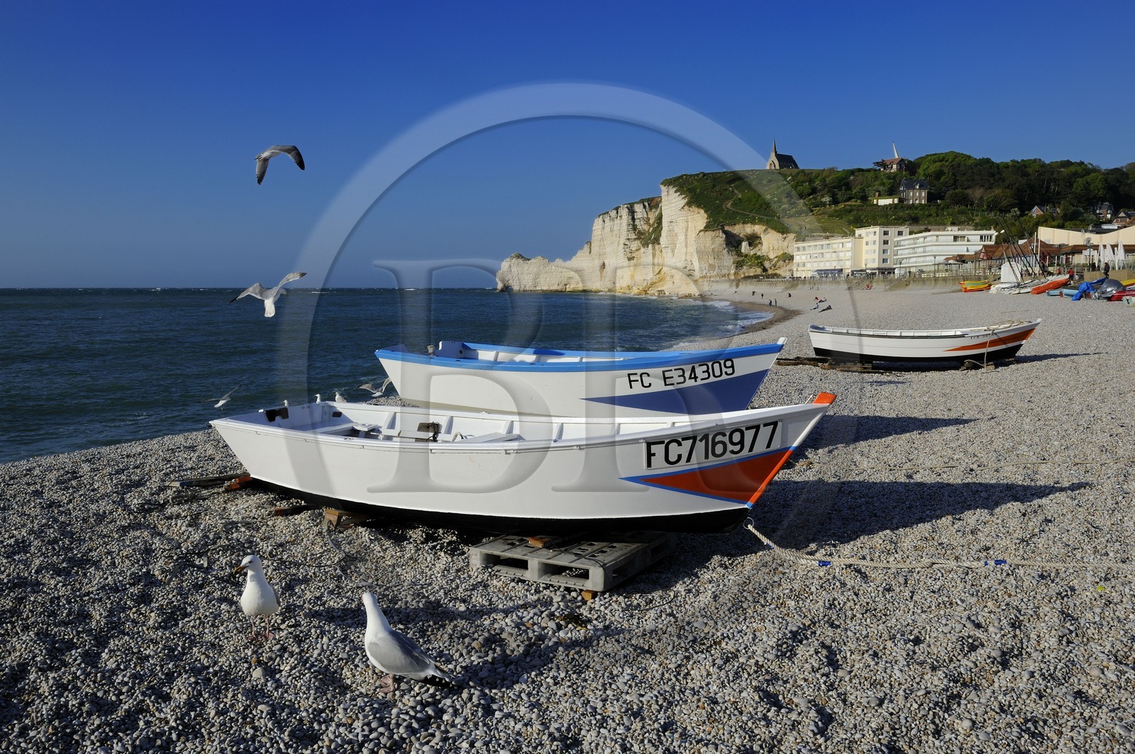France, Seine-Maritime (76), Pays de Caux, Côte d'Albâtre, Etretat, la falaise d'Amont et l'église Notre-Dame-de-la-Garde depuis la plage de la ville avec les barques de pecheurs