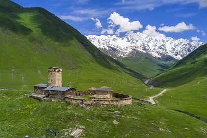 Géorgie, Haute Svanétie (Zemo Svaneti), village de Ushguli (Ouchgouli), classé Patrimoine Mondial de l'UNESCO, église Lamaria Sainte-Marie d'Ushguli du XIIème siècle et le mont Chkhara (plus haut sommet de Georgie avec 5193 m) en arrière plan (vue aérienne)