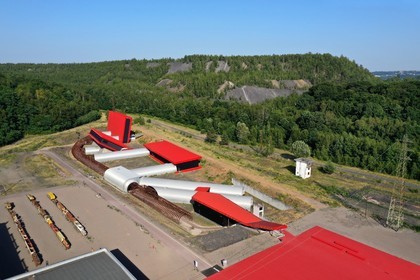 France, Moselle (57), Petite-Rosselle, le musée du carreau Wendel, les batiments construits pour héberger la reconstitution des différents types de veines de charbon de la mine et se présentent sous la forme d’un grand livre ouvert rouge qui symbolise l’histoire de la mine, terrils en arrière plan (vue aérienne)