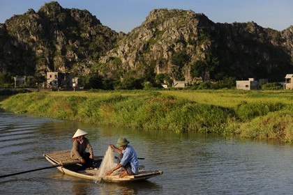Vietnam, province de Ninh Binh, village insulaire de Kenh Ga entouré de montagnes karstiques, pêcheur