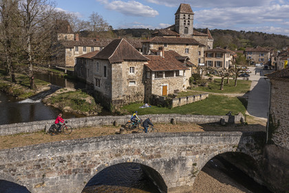 France, Dordogne (24), Périgord Vert, Saint-Jean-de-Côle, labellisé Les Plus Beaux Villages de France, cyclistes faisant la véloroute la Flow Vélo franchissant le pont médiéval du XIIème siècle, le clocher de l'église Saint-Jean-Baptiste (vue aérienne)