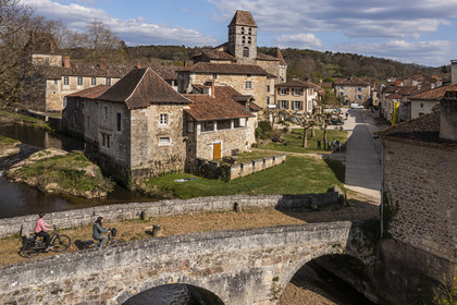 France, Dordogne (24), Périgord Vert, Saint-Jean-de-Côle, labellisé Les Plus Beaux Villages de France, cyclistes faisant la véloroute la Flow Vélo franchissant le pont médiéval du XIIème siècle, le clocher de l'église Saint-Jean-Baptiste (vue aérienne)