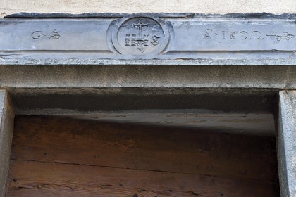 France, Alpes-Maritimes (06), vallée de la Roya (arrière-pays niçois), au pied du parc national du Mercantour, Tende, linteau de porte en schiste vert gravé du monogramme IHS signifiant Jésus sauveur des hommes qui éloigne les mauvais esprits de la maison