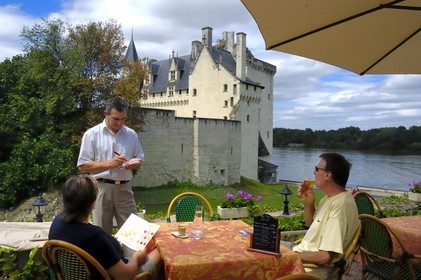 France, Maine-et-Loire (49), Vallée de la Loire classée Patrimoine Mondial de l'UNESCO, Montsoreau, labellisé Les Plus Beaux Villages de France, Château de Montsoreau au bord de la Loire, reconstruit au XV siècle et la terrasse de l'hôtel Le Bussy