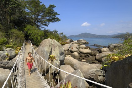 Brésil, Etat de Rio de Janeiro, Paraty, Ile Catimbau, Thomas campeurs courant sur la passerelle entre les deux îles