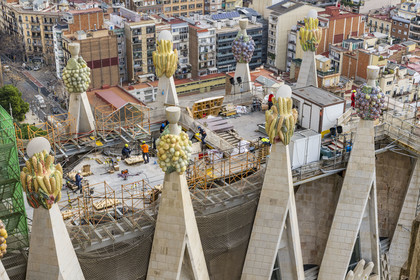 Espagne, Catalogne, Barcelone, quartier de l'Eixample, basilique de la Sagrada Familia de l'architecte du modernisme catalan Antoni Gaudi classée Patrimoine Mondial de l'UNESCO, sommets surmontés de mosaïques en forme de fruits entourant le chantier sur le toit de la nef à l'arrière de la future facade de la Gloire