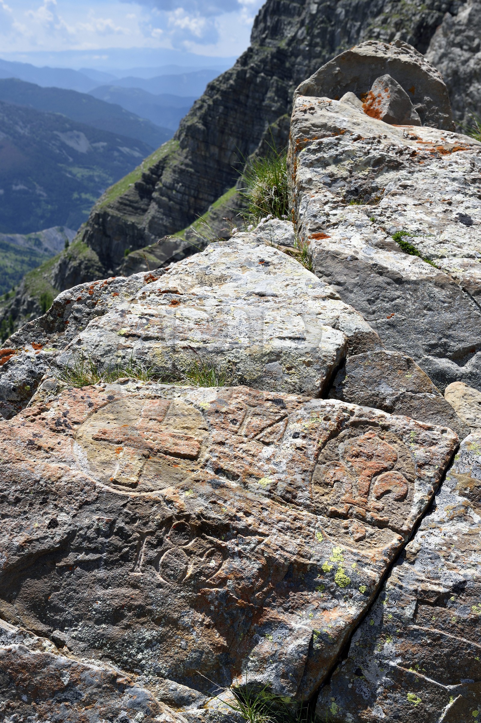 France, Alpes-de-Haute-Provence (04), Uvernet-Fours, parc national du Mercantour, vallée de l'Ubaye, sentier de randonnée du circuit des lacs du col de la Cayolle au Pas du Lausson, borne gravée sur les rochers délimitant la frontière entre le duché de Savoie et le comté de Nice, la vallée du Haut-Var et lac du Lausson (Alpes-Maritimes) en arrière plan
