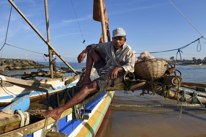 Sri Lanka, Province de l'Ouest, Negombo, pecheur sur son catamaran traditionnel après la peche du matin, sur la plage de Porathota
