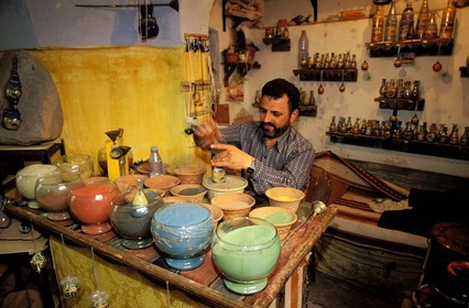 Jordanie, Madaba, artisan créant les bouteilles aux dessins de sables colorés vendues comme souvenirs aux touristes