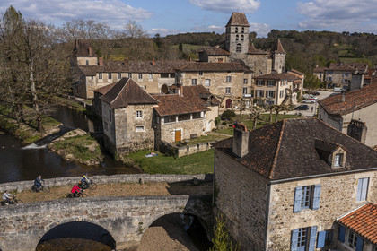 France, Dordogne (24), Périgord Vert, Saint-Jean-de-Côle, labellisé Les Plus Beaux Villages de France, cyclistes faisant la véloroute la Flow Vélo franchissant le pont médiéval du XIIème siècle, le clocher de l'église Saint-Jean-Baptiste (vue aérienne)