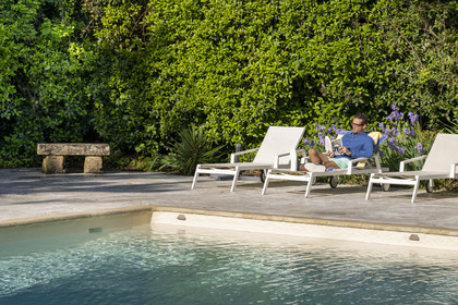 France, Vaucluse (84), Dentelles de Montmirail, le village médiéval de Séguret, labellisé Les Plus Beaux Villages de France, Hotel Domaine de Cabasse, lecture en bord de piscine