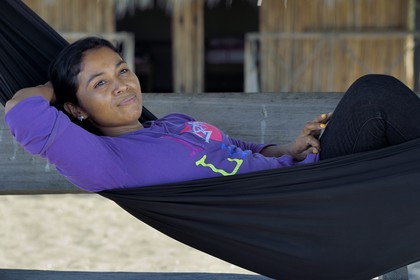 Nicaragua, la côte pacifique de Leon, parc national Isla Juan Venado, femme de la communauté amérindienne de Sutiava dans un hamac sur la plage
