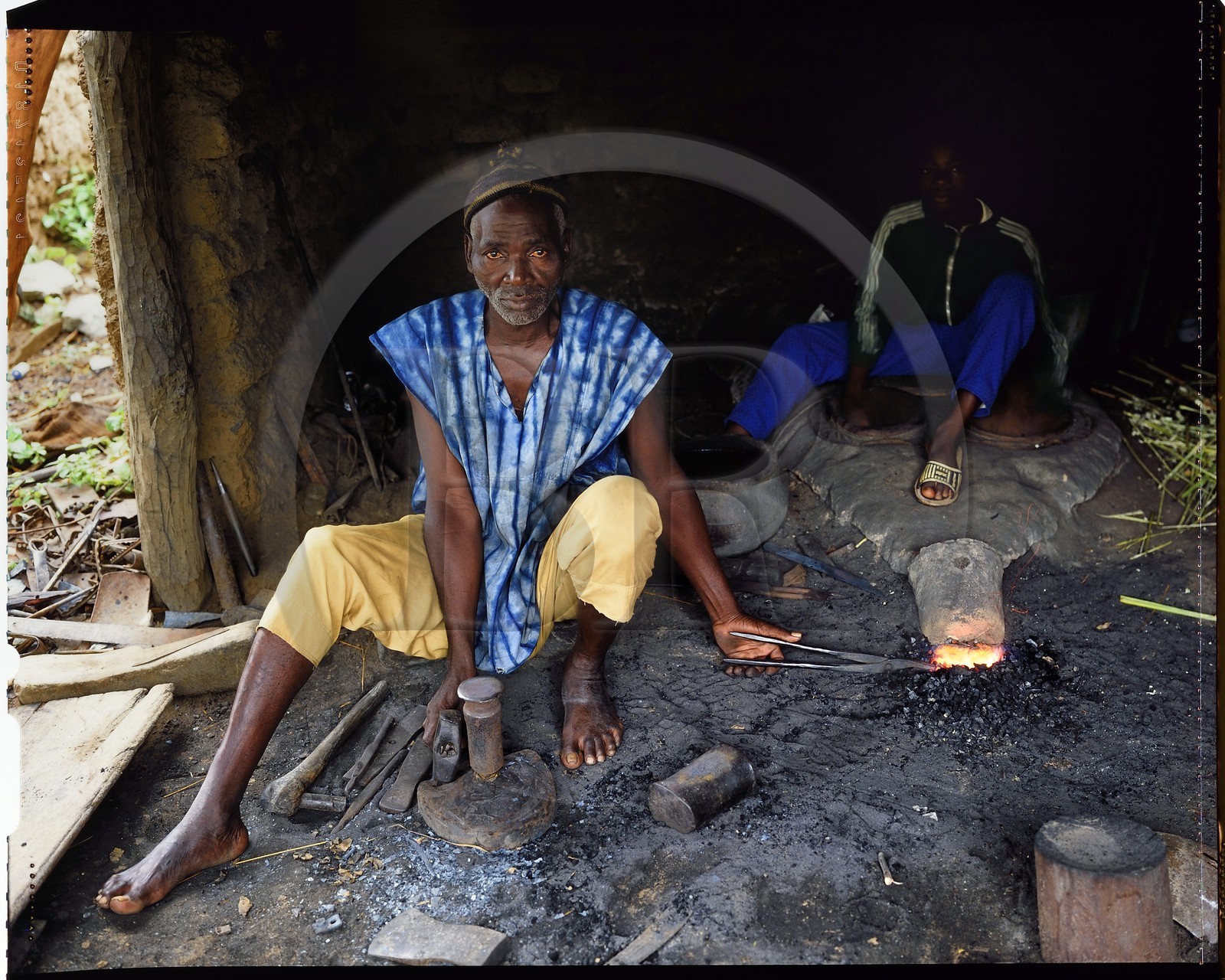 Burkina Faso, province de Poni, pays des Lobi, Loropéni, forgeron avec son apprenti, il est l'artisan qui fabrique l'outillage en fer (houes, têtes de flèches...) mais forge aussi un lien fort avec le monde des ancêtres