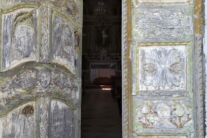 France, Haute-Corse (2B), Castagniccia, village de Piazzole d'Orezza, église paroissiale de l'Annonciation, la tradition rapporte qu’un bandit repenti sculpta sur la jolie porte bariolée de l’église plusieurs scènes bibliques (l’annonce faite à Marie, David et Goliath) et un beau décor de vigne et de blé