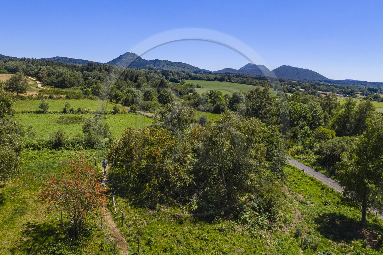 France, Puy-de-Dôme (63), Le Bouchet, Parc naturel régional des Volcans d'Auvergne, randonneur sur le sentier des puys de Jumes et de la Coquille, en arrière plan le volcan le Puy Chopine à gauche et le Puy de Dome à droite (vue aérienne)