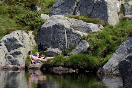Norvège, Rogaland, région du Lysefjord, randonneurs se reposant au bord d'un petit lac sur le chemin de randonnée menant au Rocher de La Chaire (Preikestolen)