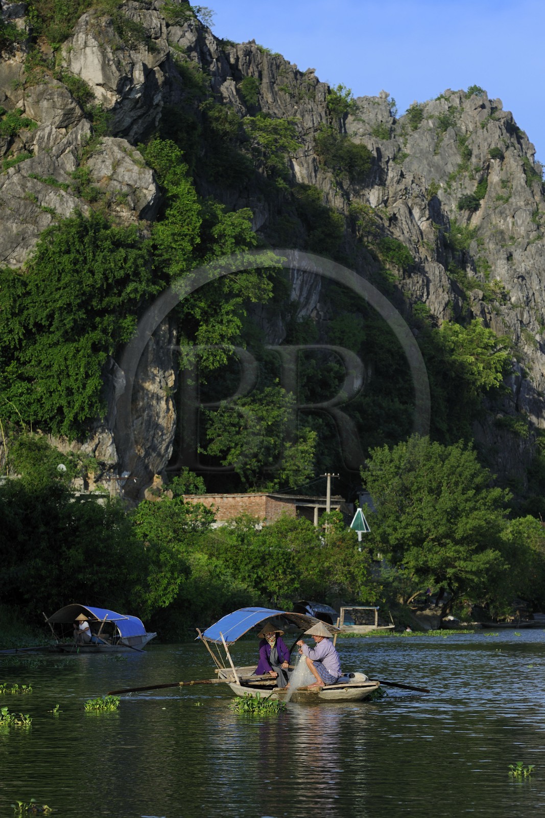 Vietnam, province de Ninh Binh, village insulaire de Kenh Ga entouré de montagnes karstiques, pêcheur