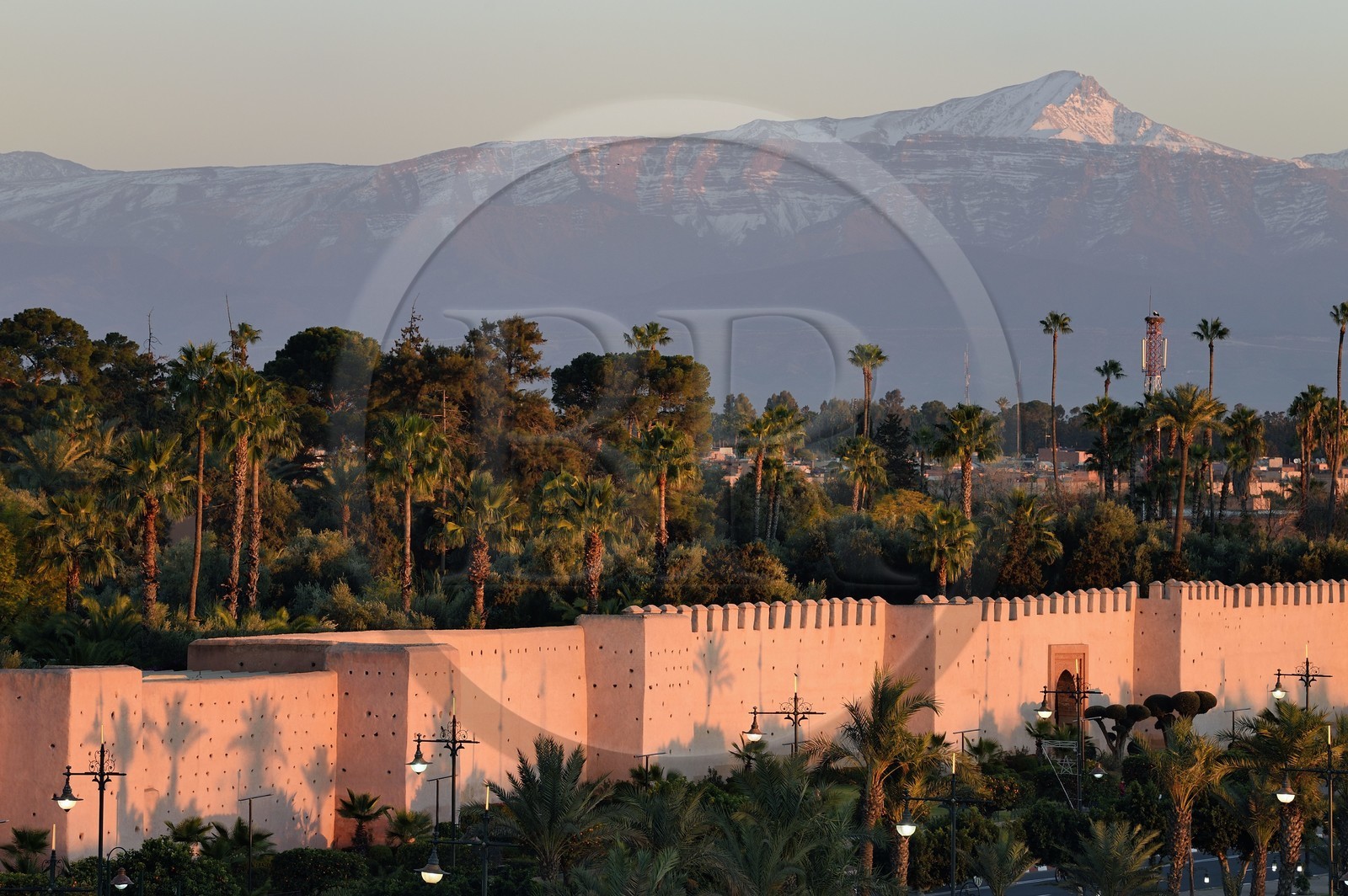 Maroc, Haut-Atlas, Marrakech, ville impériale, Médina classée Patrimoine Mondial de l'UNESCO, les remparts de la ville et le sommet de l'Oukaïmeden dans l'Atlas enneigé en arrière plan au soleil couchant