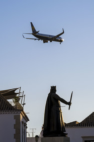 Portugal, Algarve, Faro, avion de ligne de la compagnie Ryanair à l'atterrissage au dessus de la vieille ville, statue Afonso III