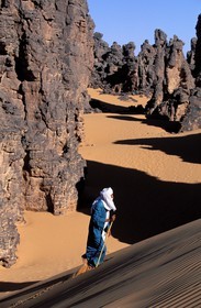 Libye, région du désert, Le Fezzan (Sahara), Touareg marchant entre les aiguilles de grès du Tassili de Maghidet (frontière algérienne)