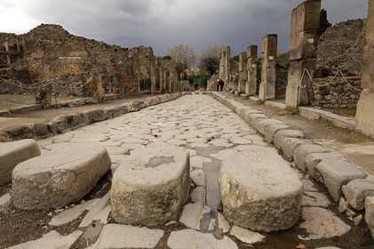 Italie, Campanie, Pompei, site archéologique classé Patrimoine Mondial de l'UNESCO, ancienne rue pavée de la ville, passage piéton