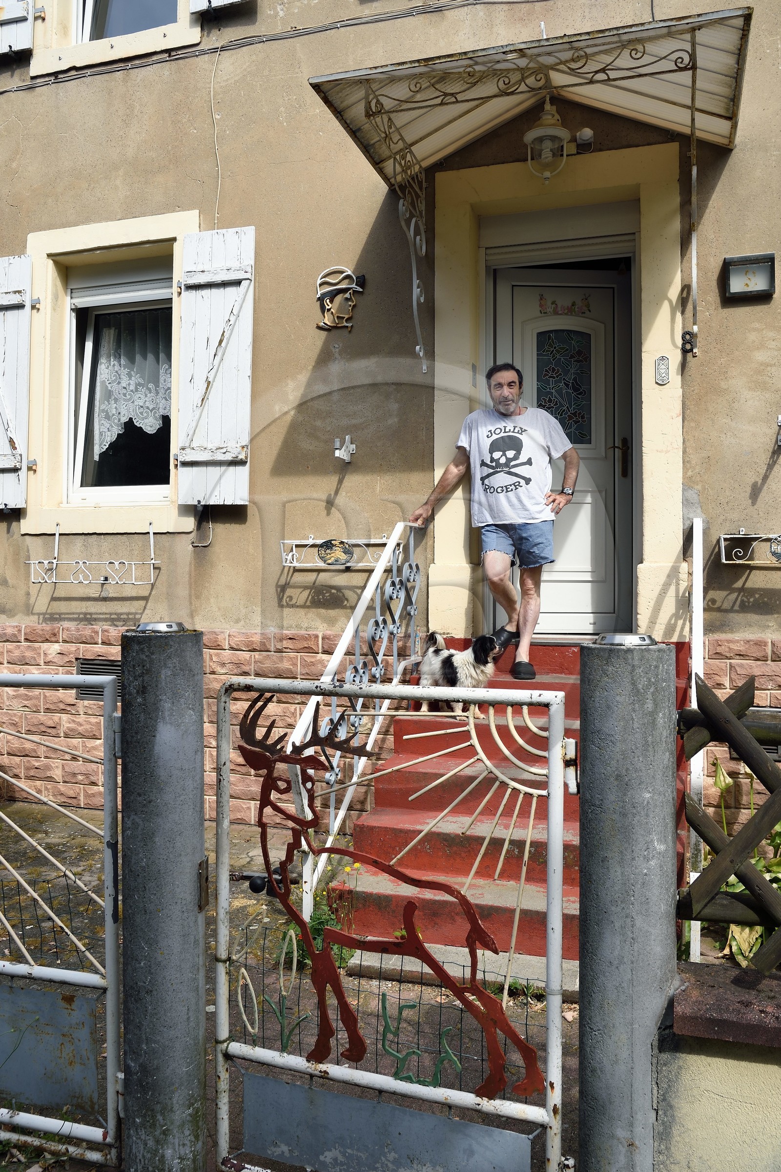 France, Moselle (57), Petite-Rosselle, ancien quartier de logements ouvriers de la cité industrielle crée par la famille Wendel pour les mines de charbon, l'ancien mineur Raphael Alcudia Gomez devant sa maison de mineur datant de 1908