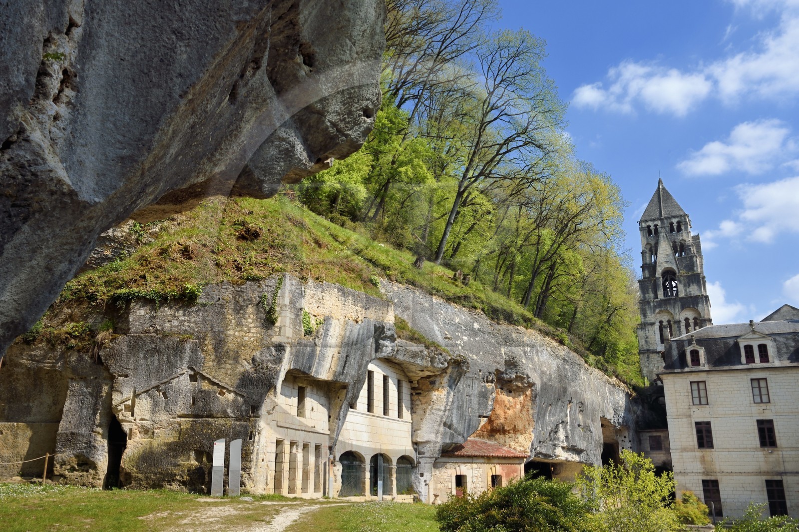 France, Dordogne (24), Brantôme, l'abbaye bénédictine Saint-Pierre de Brantôme, les anciens habitats troglodytiques et les grottes nichées dans la falaise et le clocher de l'église abbatiale (XIe siècle) en arrière plan