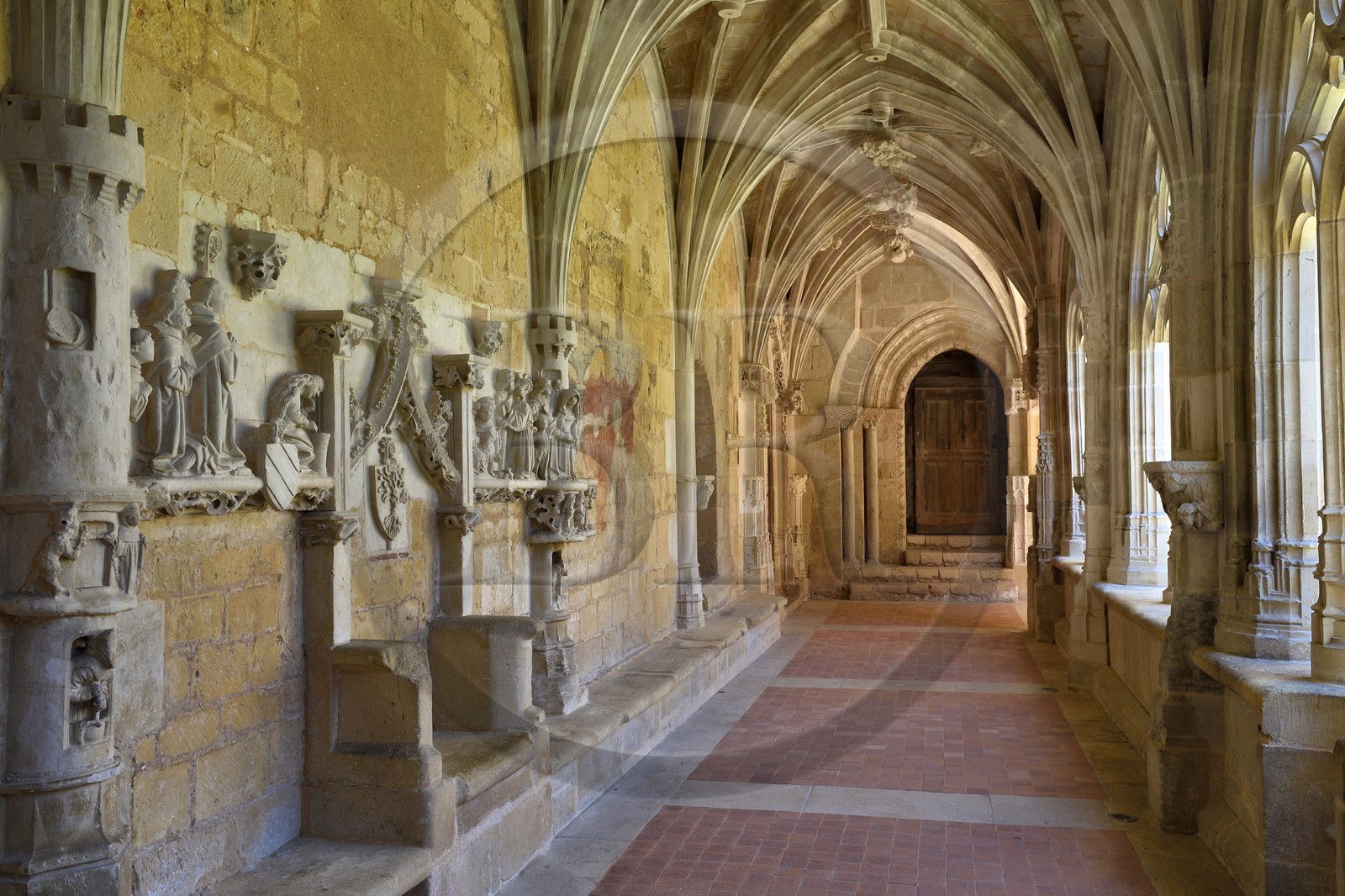 France, Dordogne (24), Périgord Noir, Le Buisson-de-Cadouin, abbaye de Cadouin, étape sur le chemin de Compostelle, site classé Patrimoine Mondial de l'UNESCO, le cloitre du XVe siècle, bas-relief de la passion du Christ, le banc des moines avec le siège de l'Abbé et Porte Romane en arrière plan