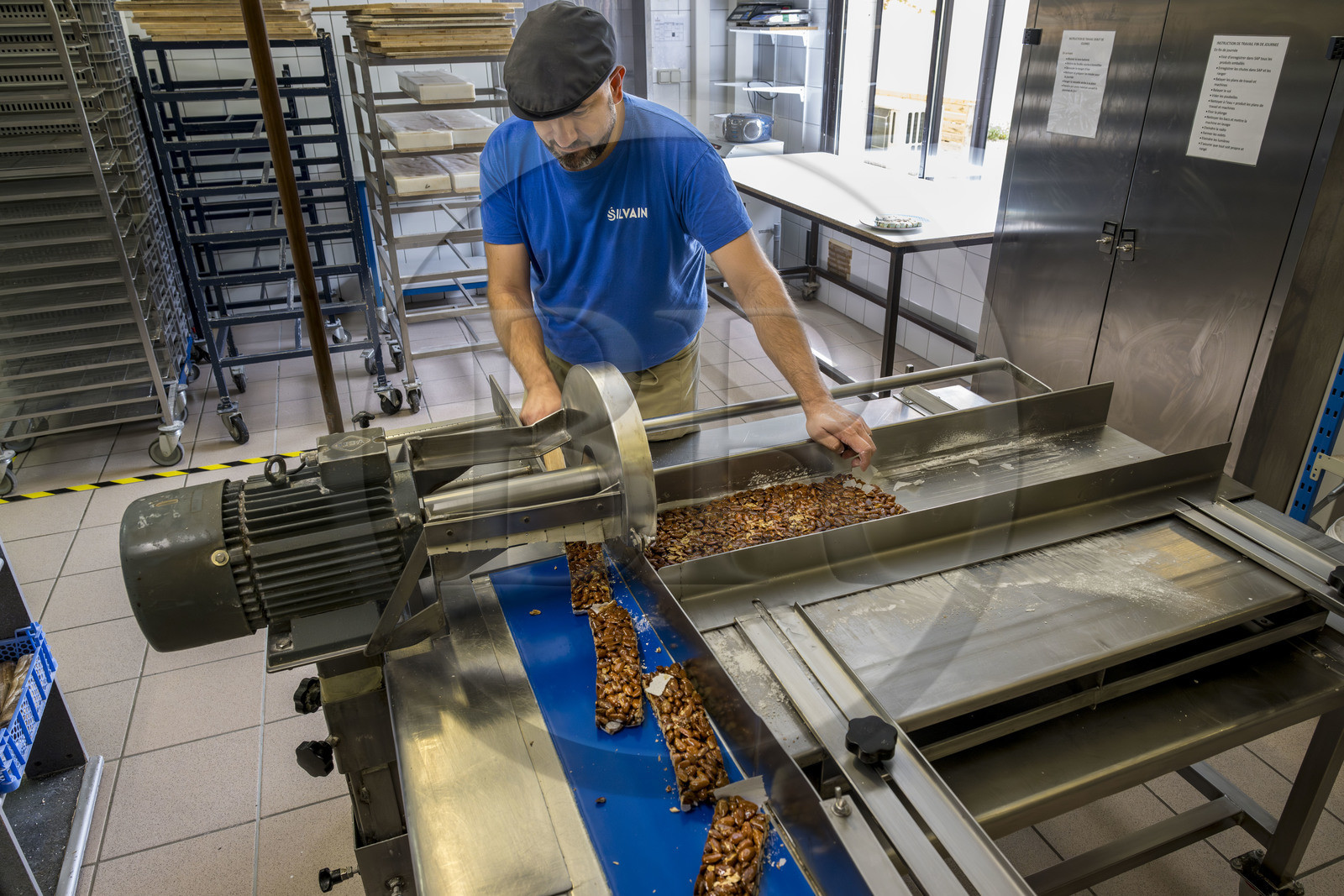 France, Vaucluse (84), Saint Didier, dans l'atelier de fabrication des Nougats Silvain, paysans nougatiers, Charles-Henri Bagnol confectionne une plaque de nougat noir, découpe des plaques de nougat