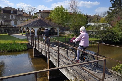 France, Dordogne (24), Saint-Pardoux-la-Rivière, cyclistes traversant le petit pont sur la Dronne pour rejoindre le vieux lavoir en arrière plan