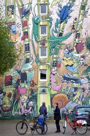 France, Charente (16), Angoulême, Rue Pierre Sémard , cycliste faisant la véloroute La Flow Vélo devant Le Jardin Extraordinaire, mur peint d'après un dessin original de Florence Cestac et réalisé par la Cité de la création en 2001