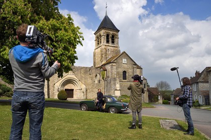 France, Yvelines (78), Montchauvet, tournage pour la télévision du Village Préféré des Français avec Stéphane Bern, Stéphane Bern au volant d'une MG cabriolet devant l'église Sainte Marie-Madeleine