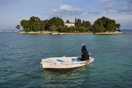 Croatie, Dalmatie, côte dalmate, Ile d’Ugljan, Preko, le frère franciscain Bozo Susic quittant le Monastère Franciscain de l'îlot Galovac sur sa barque