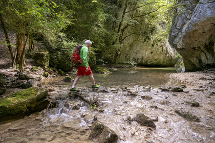 France, Vaucluse (84), Parc naturel régional du Mont Ventoux, Monieux, Gorges de La Nesque, randonneur traversant la Nesque au gué de la chapelle Saint-Michel