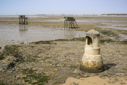 France, Charente-Maritime (17), Port-des-Barques, Ile Madame, le Puits des Insurgés construit par des Communards déportés en 1871 et cabanes sur pilotis appelées carrelets à marée basse en arrière plan