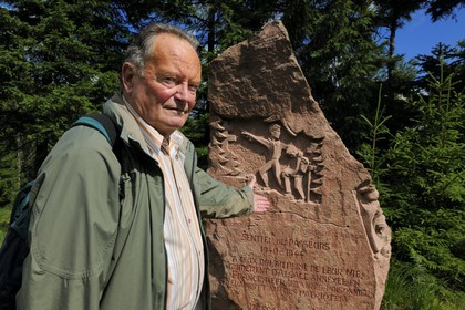 France, Vosges (88), chemin des passeurs au Donon sur la trace de la filière d'évasion du Rehtal, Hubert Ledig, dont le père, (du même prénom) était passeur pendant la deuxième guerre mondiale devant le monument aux passeurs - pierre commémorative sculptée par Raymond Keller, un artiste de Molsheim