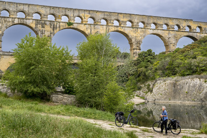 France, Gard (30), le Pont du Gard classé Patrimoine Mondial de l'UNESCO, Grand Site de France, cycliste prenant une pause devant le pont aqueduc romain qui enjambe le Gardon