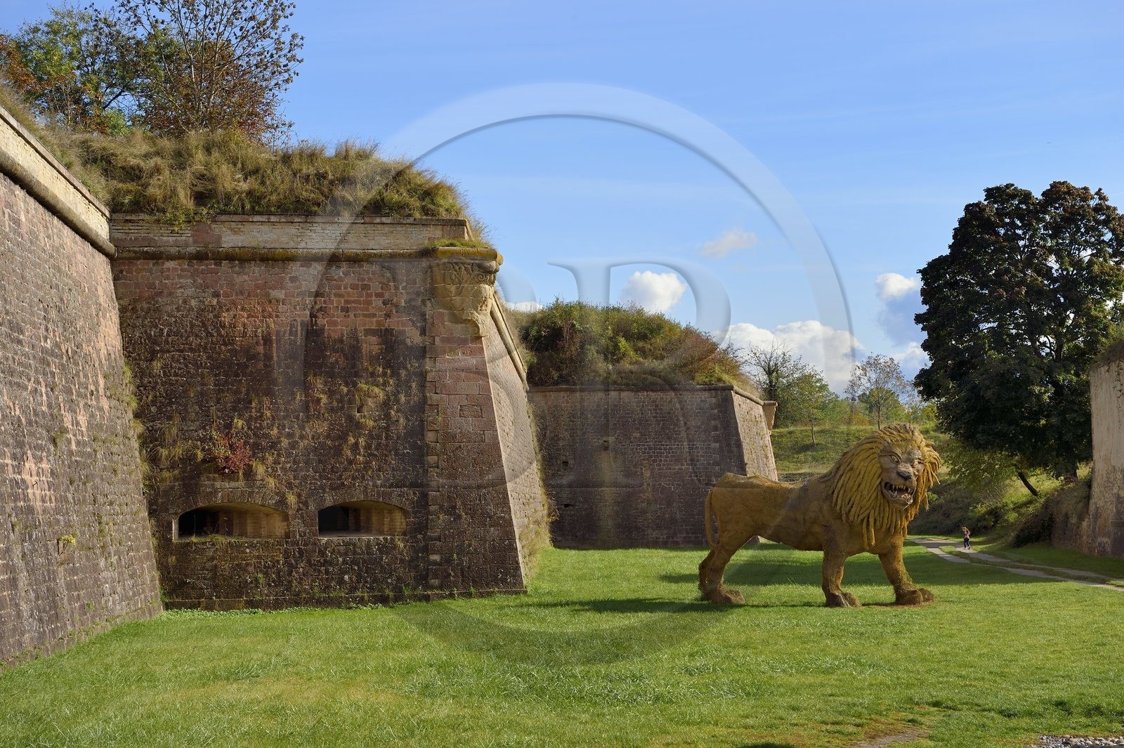 France, Haut-Rhin (68), Neuf-Brisach, ville fortifiée par Vauban, classée Patrimoine Mondial de l'UNESCO, fossé et fortifications au niveau de la Porte de Belfort au sud-ouest, sculpture en paille représentant un lion créé pour Remp'arts