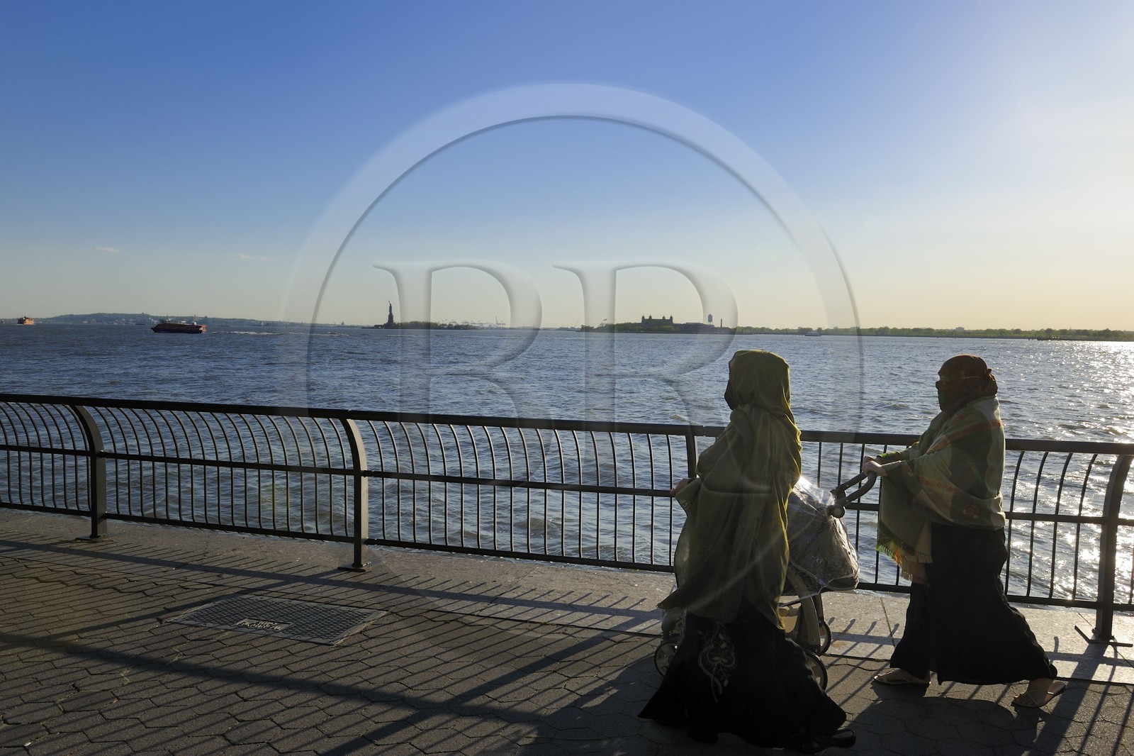 Etats-Unis, New York, Manhattan, pointe Sud, femmes voilée en promenade sur Battery Park et la Statue de la Liberté en arrière plan