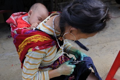 Vietnam, province de Lao Cai, région de Sapa, la minorité Hmong Noir, travaux de couture et de teinture au bleu indigo