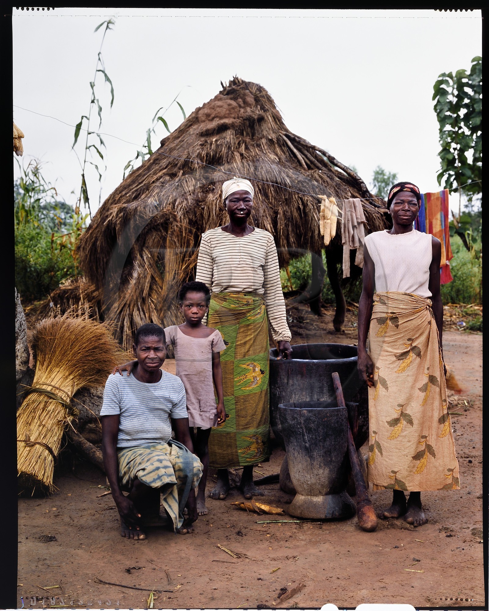 Burkina Faso, province de Poni, pays des Lobi, Loropéni, groupe de femmes dans la cour de la maison familiale préparant le mil et le beurre de karité