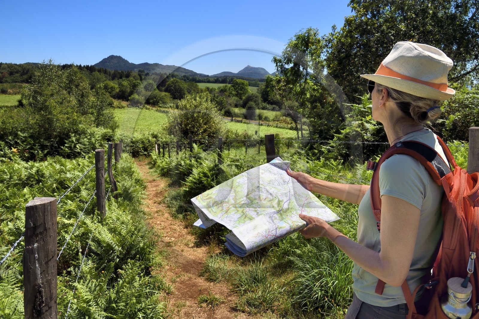 France, Puy-de-Dôme (63), Le Bouchet, Parc naturel régional des Volcans d'Auvergne, randonneuse sur le sentier des puys de Jumes et de la Coquille, en arrière plan le volcan le Puy Chopine à gauche et le Puy de Dome à droite