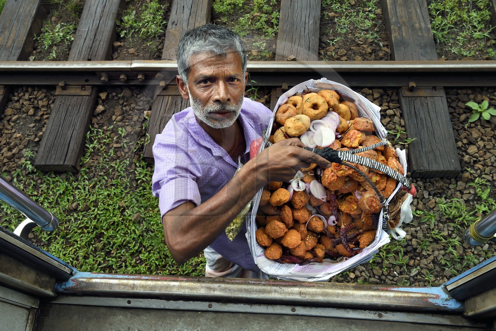 Sri Lanka, Province du Centre, trajet en train dans la région montagneuse de la culture du thé entre Hatton et Ella, gare de Talawakele, vendeur ambulant de beignets de crevettes et de wade
