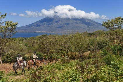 Nicaragua, Ile d'Ometepe sur le lac Nicaragua, cavaliers en randonnée et le volcan Conception (1610 m) toujours en activité en arrière plan