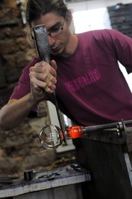 France, Moselle (57), Meisenthal, souffleur au Centre international d’Art verrier (CIAV), fabrication d'une boule de Noël en verre. La canne de verre posée sur un banc appelé « gamin mécanique », Thibaut crée avec la pince l’étranglement