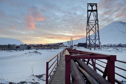 Norvège, Svalbard, Spitzberg, Longyearbyen, tuyaux de chauffage thermique qui traversent Longyearbyen hors-sol à cause du permafrost et anciens chevalements de transport du charbon