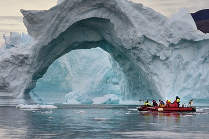 Groenland, cote Nord-Ouest, mer de Baffin, Inglefield Fjord vers Qaanaaq, iceberg formant un arche et un PolarCirkel boat (zodiac) d'exploration du bateau de croisière MS Fram de la compagnie Hurtigruten