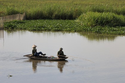 Vietnam, province de Ninh Binh, pêcheurs sur un canal, ramant avec ses pieds